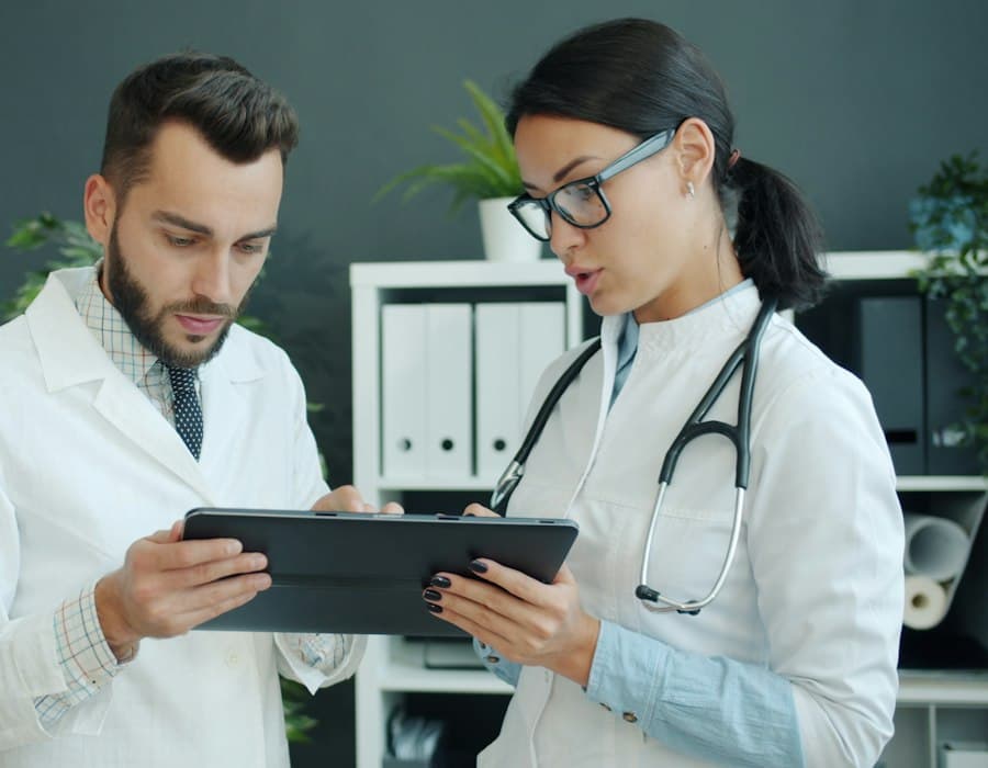 Dos médicos revisando un expediente en una tablet